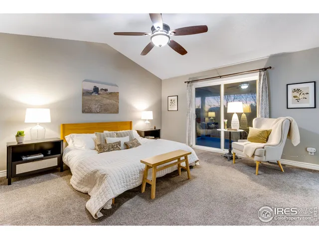 a spacious bedroom with a bed a couch and a chandelier