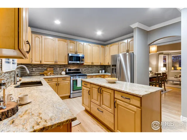 a kitchen with kitchen island granite countertop a refrigerator stove microwave and sink