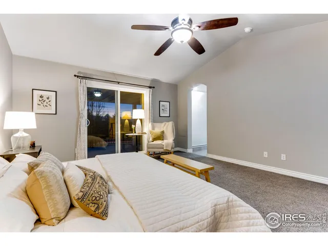 a bedroom with a bed ceiling fan and view of bathroom