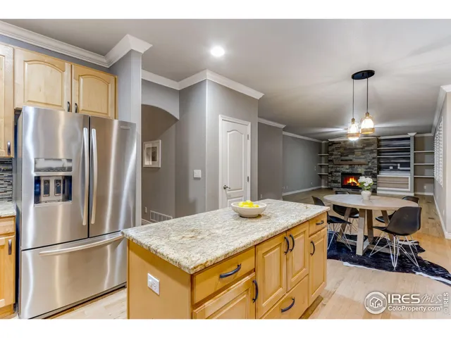 a kitchen with stainless steel appliances granite countertop a sink refrigerator and cabinets
