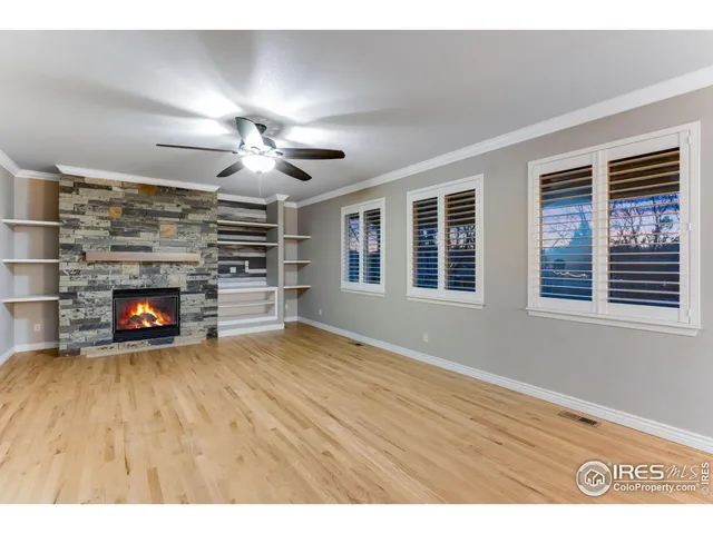a view of an empty room with a fireplace and a window