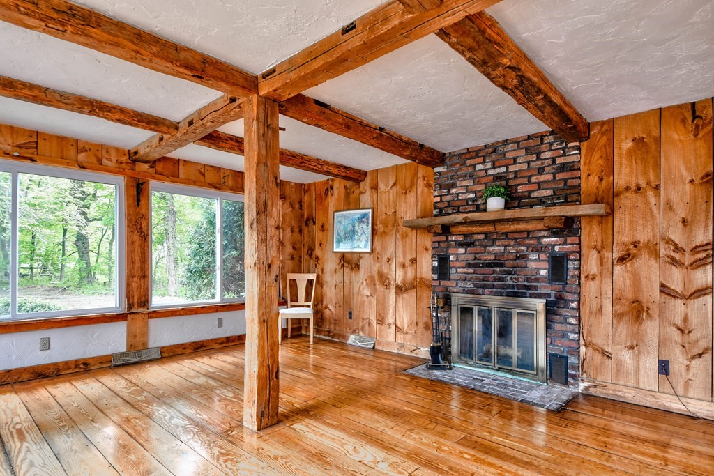 186 Edmands Road Framingham, MA 01701 - Photo 13 of 26 a living room with a fireplace a flat screen tv and a floor to ceiling window