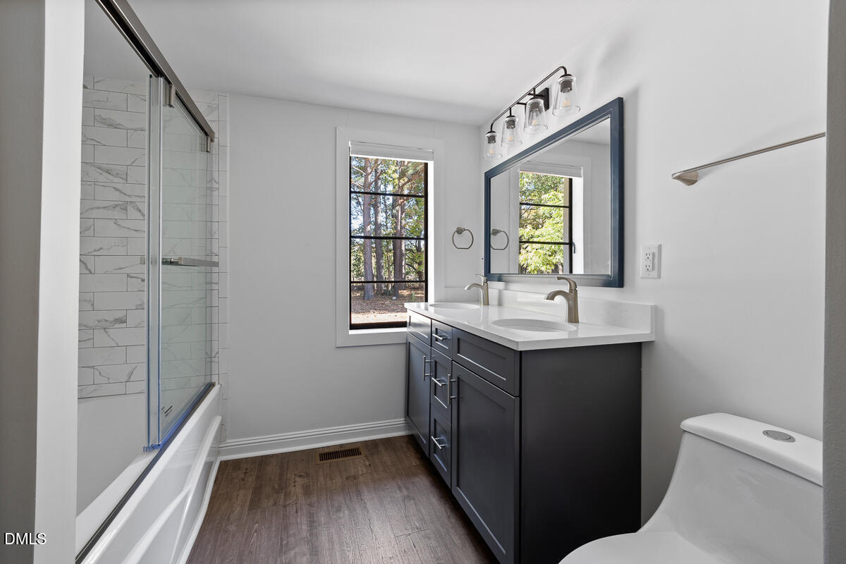 7700 Humie Olive Road Apex, NC 27502 - Photo 10 of 13 a bathroom with a sink mirror toilet and next to a window