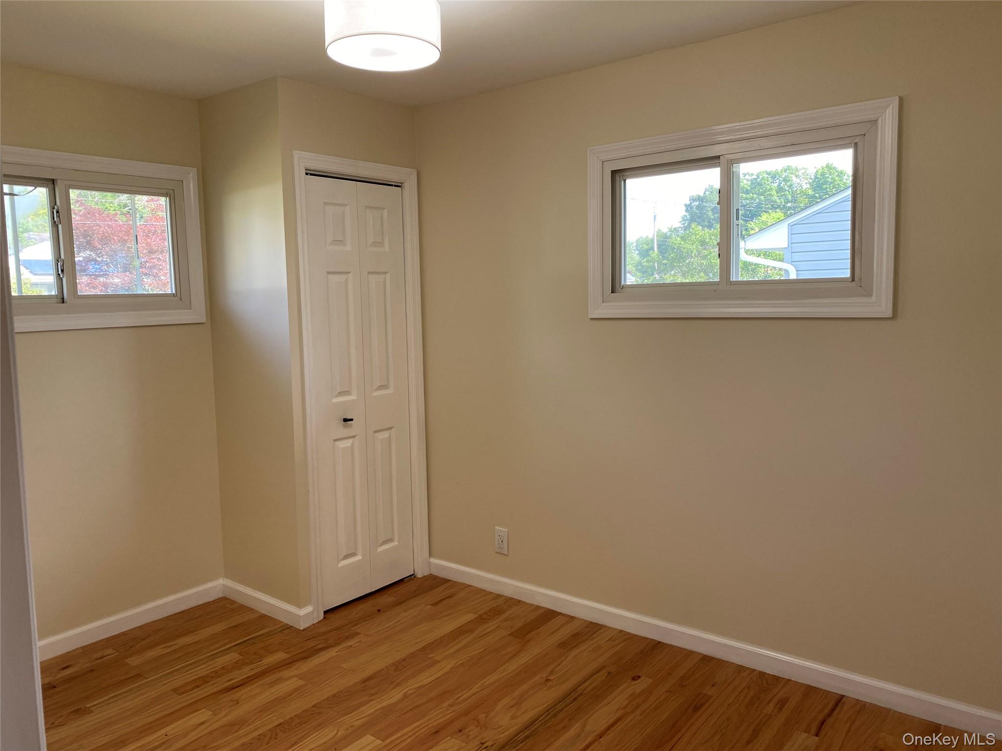 5 Smith Road Cornwall, NY 12518 - Photo 29 of 32 Bedroom 3 - Unfurnished bedroom with light wood-type flooring, a closet, and multiple windows