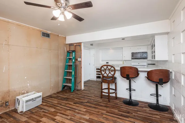 a view of a kitchen with stainless steel appliances kitchen island granite countertop a stove a sink and a refrigerator