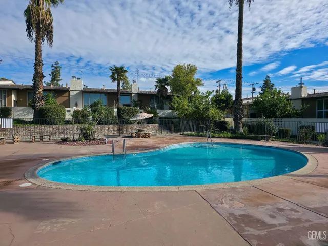 a view of a swimming pool with a yard and plants