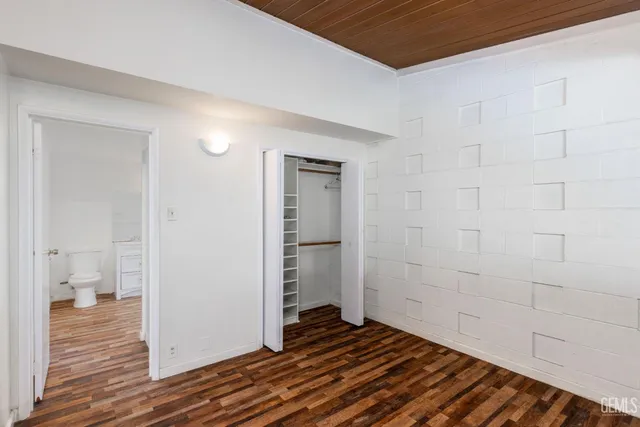 a view of a room with wooden floor and a bathroom