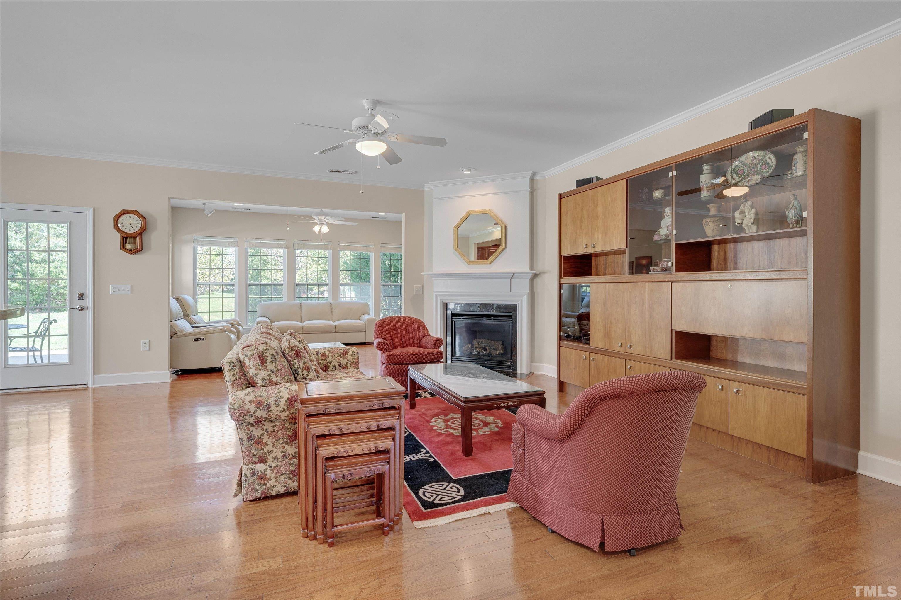 315 Beckingham Loop Cary, NC 27519 - Photo 10 of 34 a living room with furniture a fireplace and a dining table with wooden floor