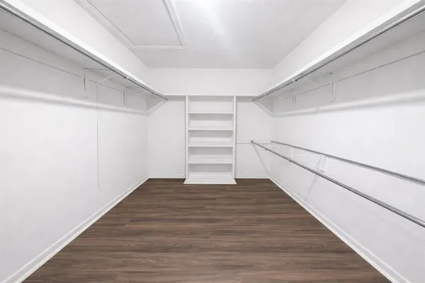a view of an empty room with wooden floor and entryway