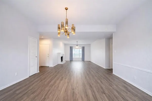 a view of a livingroom with wooden floor and a chandelier