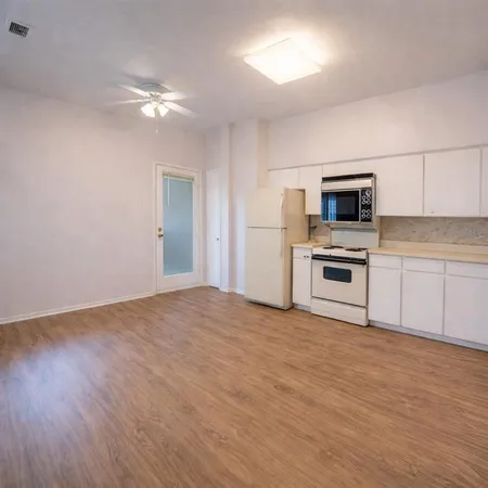 a view of kitchen with microwave and wooden floor