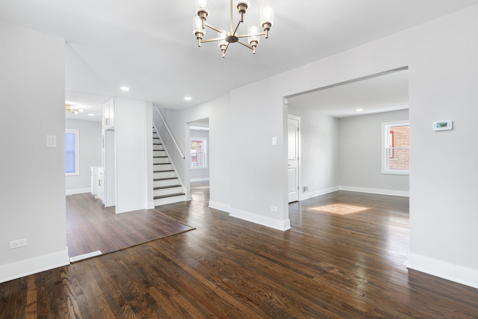 9633 South Yale Avenue Chicago, IL 60628 - Photo 8 of 26 a view of an empty room with wooden floor and a ceiling fan