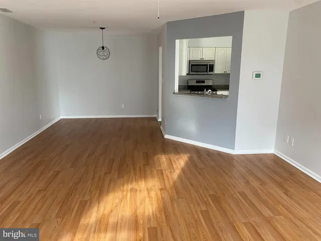 a view of empty room with wooden floor and sink