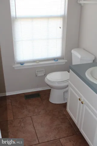 a bathroom with a toilet a sink and a window