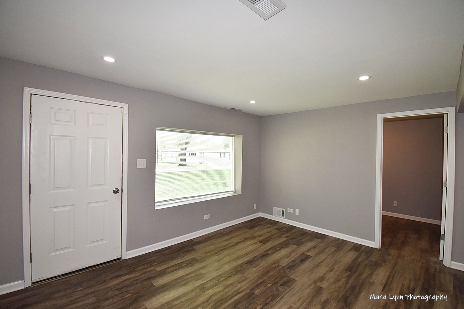 2413 Pecan Street Joliet, IL 60435 - Photo 4 of 14 an empty room with wooden floor and windows