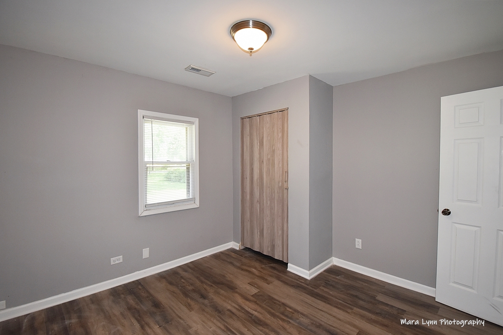 2413 Pecan Street Joliet, IL 60435 - Photo 6 of 14 an empty room with wooden floor and windows