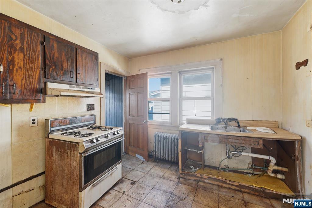 1024 Julia Street Elizabeth, NJ 07201 - Photo 14 of 30 a kitchen with stainless steel appliances a stove a sink dishwasher and cabinets