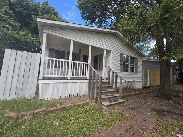 a view of a house with backyard and a tree