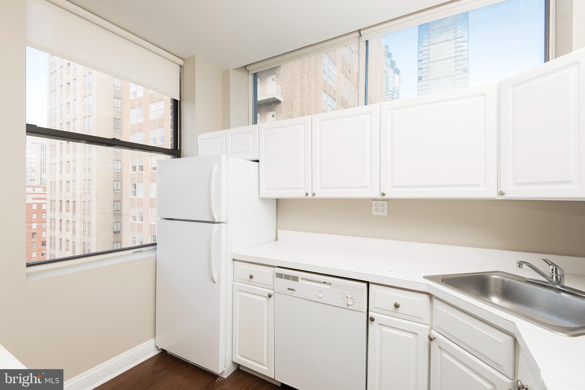 220 South 16th Street, Unit 1102 Philadelphia, PA 19102 - Photo 11 of 26 a kitchen with granite countertop white cabinets and white appliances