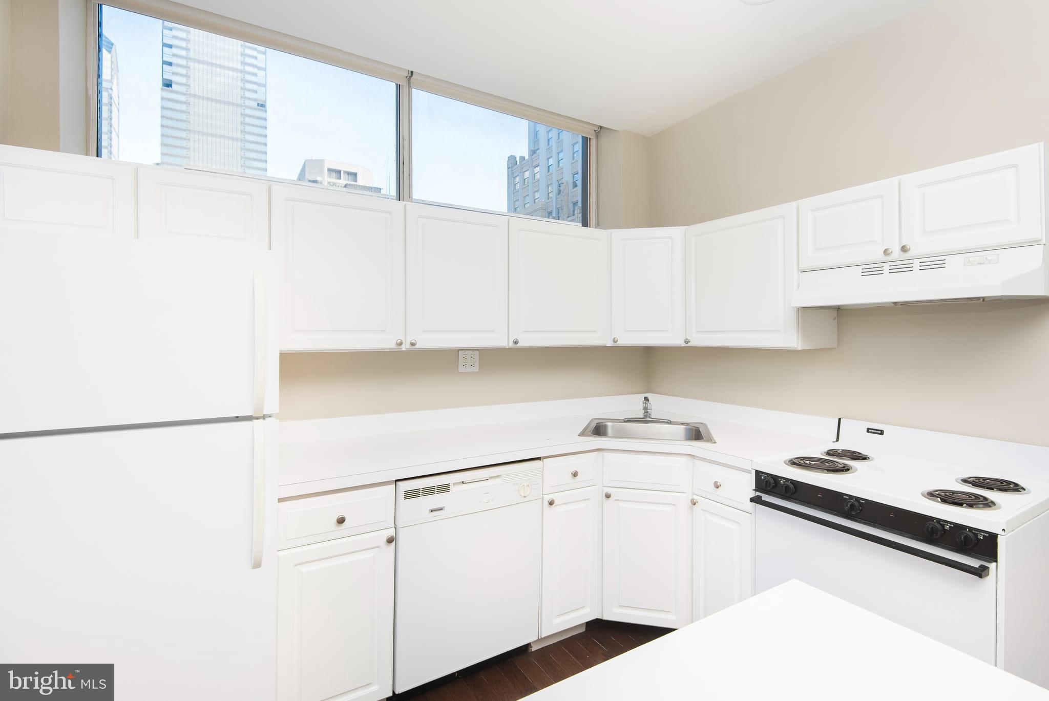 220 South 16th Street, Unit 1102 Philadelphia, PA 19102 - Photo 13 of 26 a kitchen with granite countertop white cabinets and white appliances