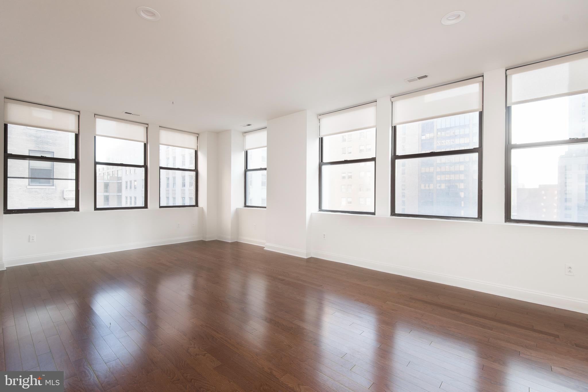 220 South 16th Street, Unit 1102 Philadelphia, PA 19102 - Photo 5 of 26 a view of an empty room with wooden floor and a window