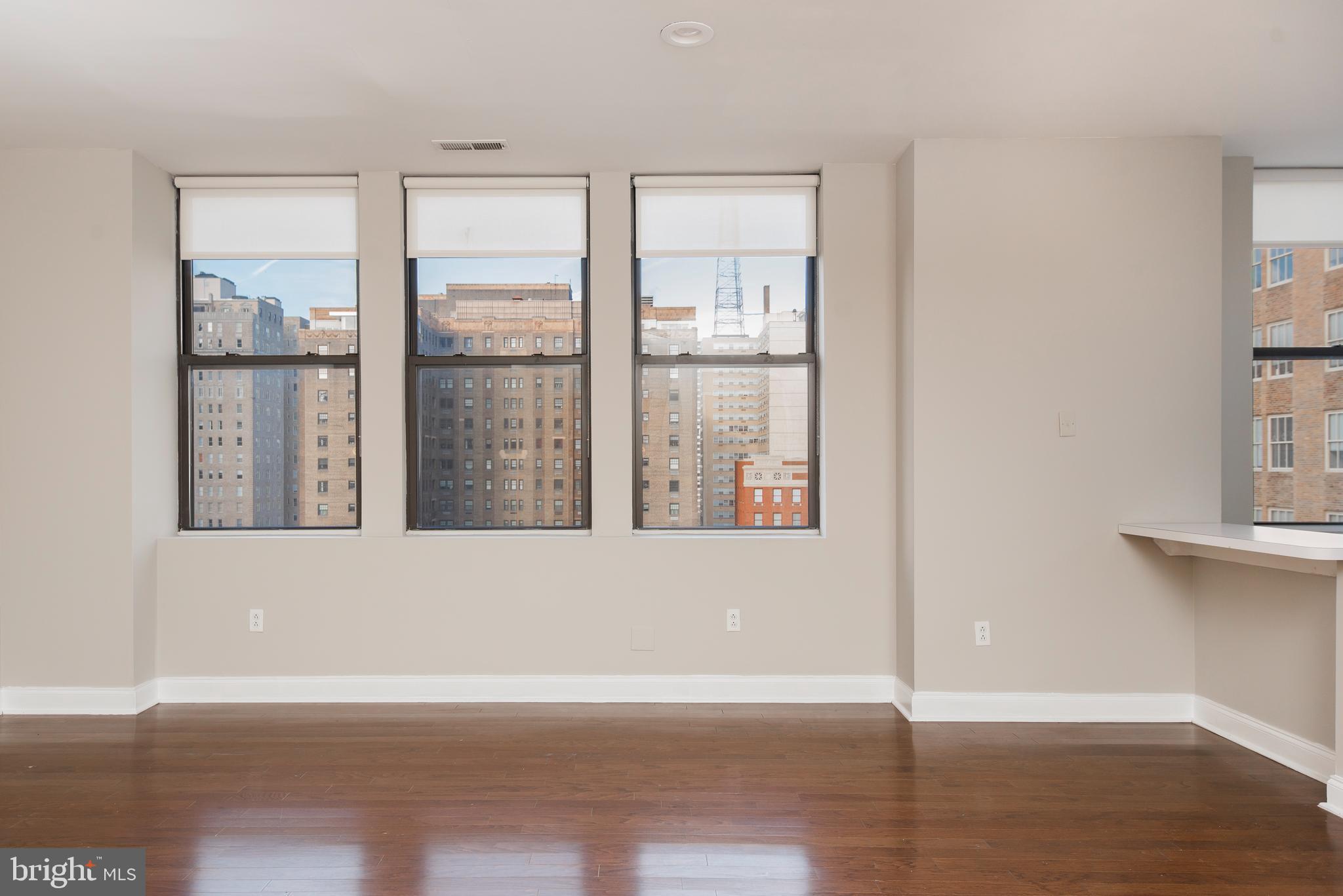 220 South 16th Street, Unit 1102 Philadelphia, PA 19102 - Photo 7 of 26 an empty room with wooden floor and windows