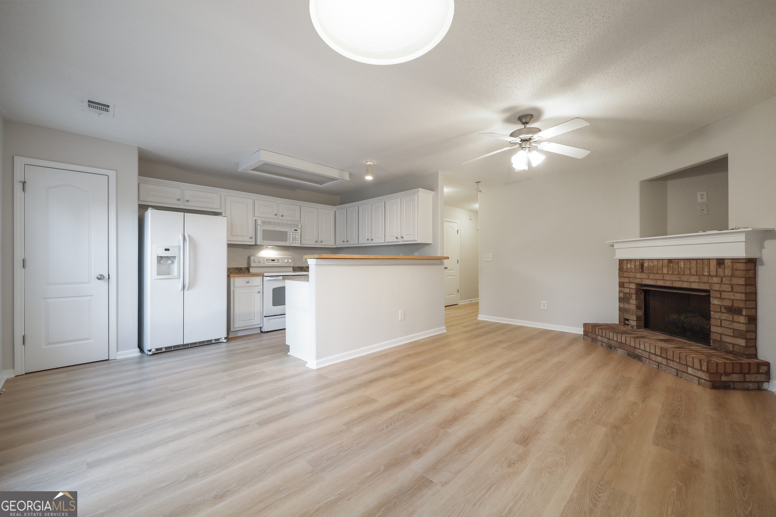 1442 Box Circle Winder, GA 30680 - Photo 4 of 25 a view of a livingroom with a fireplace a ceiling fan and wooden floor