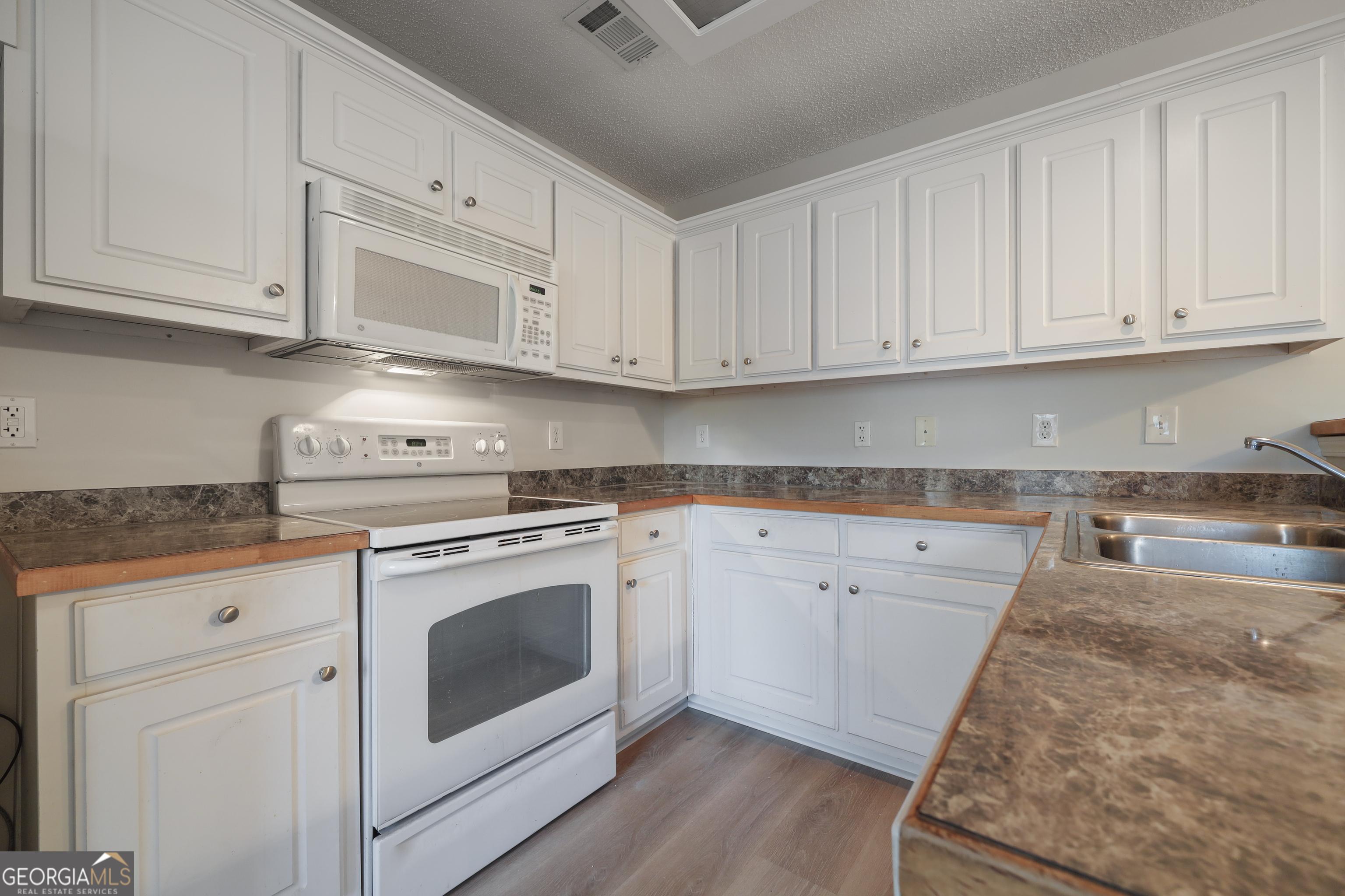 1442 Box Circle Winder, GA 30680 - Photo 7 of 25 a kitchen with granite countertop white cabinets and white appliances