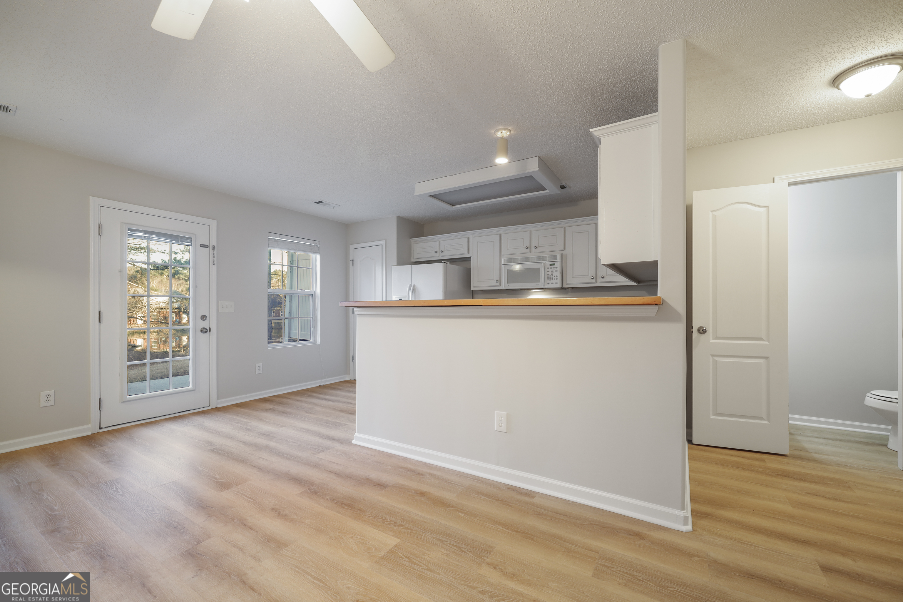 1442 Box Circle Winder, GA 30680 - Photo 8 of 25 an empty room with wooden floor and a kitchen