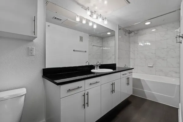 a bathroom with a sink a large mirror and a toilet