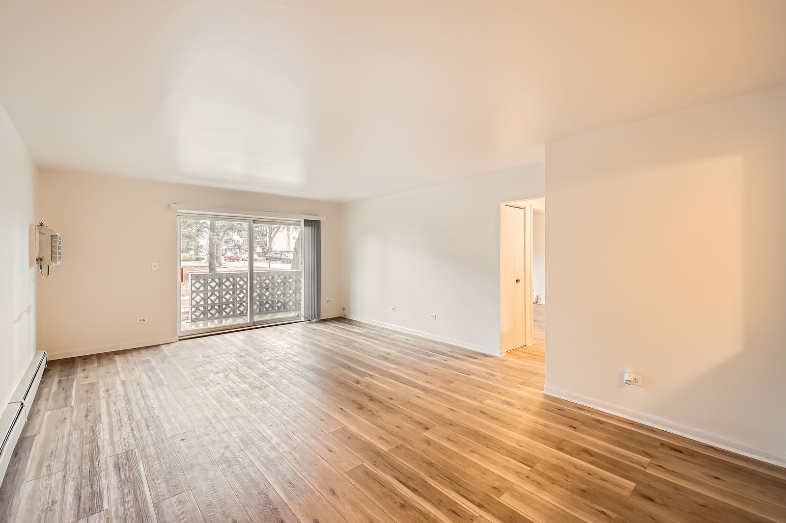 2230 South Goebbert Road, Unit 147 Arlington Heights, IL 60005 - Photo 2 of 11 an empty room with wooden floor and windows