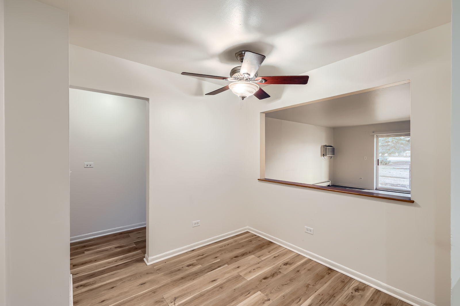 2230 South Goebbert Road, Unit 147 Arlington Heights, IL 60005 - Photo 6 of 11 a view of a room with a ceiling fan and wooden floor