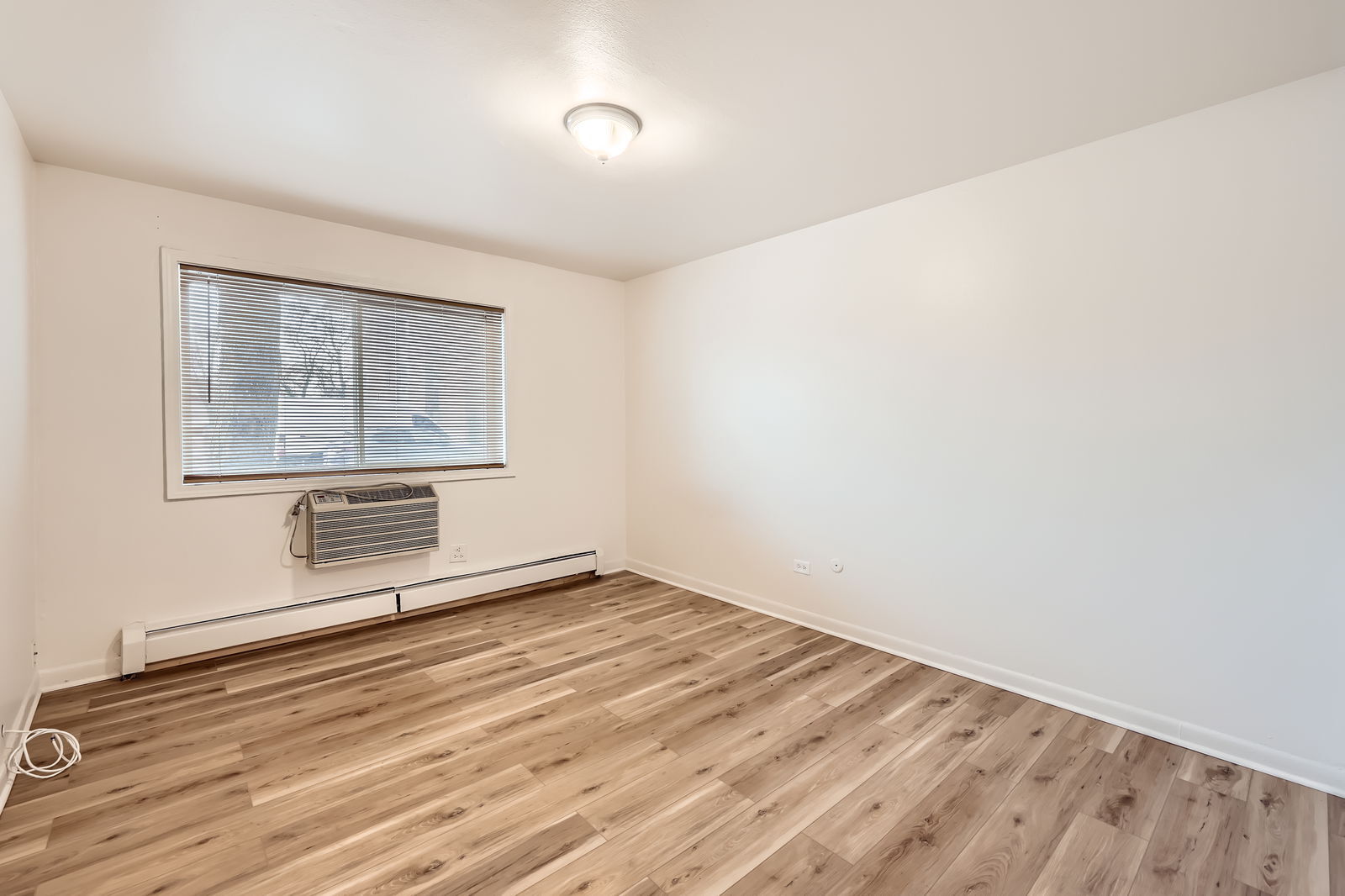 2230 South Goebbert Road, Unit 147 Arlington Heights, IL 60005 - Photo 8 of 11 an empty room with wooden floor and windows