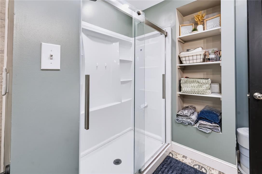 74 Turkey Road Kempton, PA 19529 - Photo 22 of 65 Modern shower enclosure with sleek glass doors and practical built-in shelving offer a convenient bathing space.