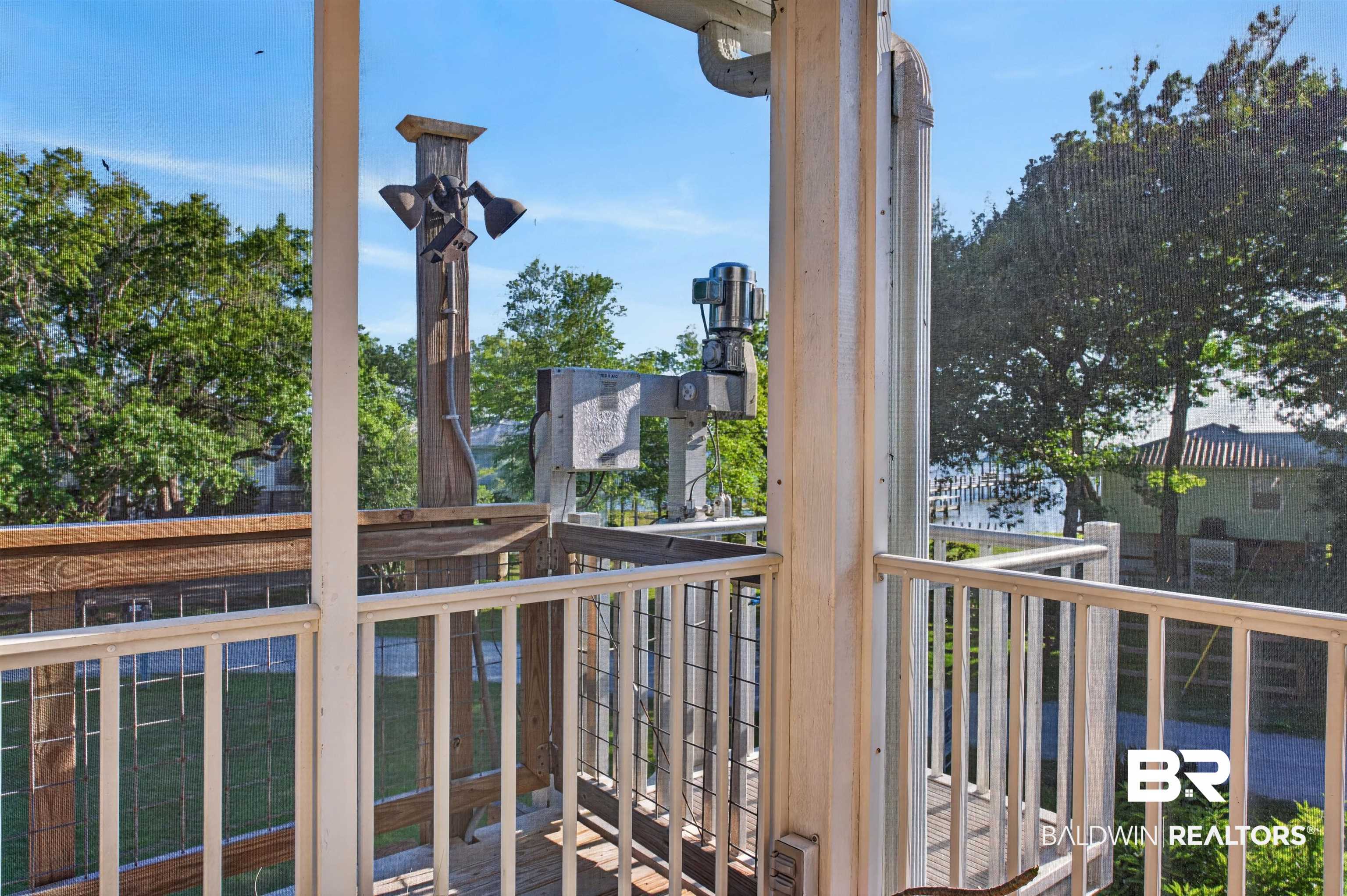 9624 North Bay Street Foley, AL 36535 - Photo 39 of 59 Outdoor balcony featuring white railings, a wooden deck, and a screened enclosure