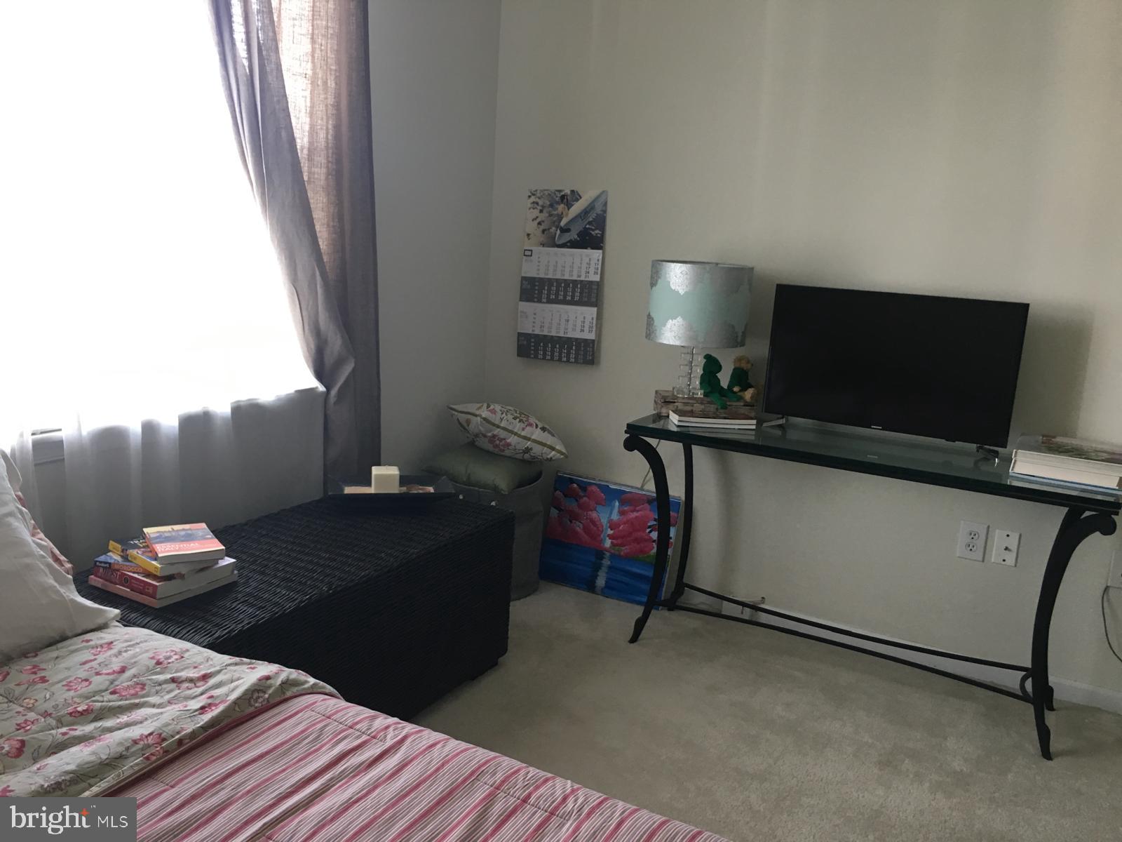 19609 Galway Bay Circle, Unit 303 Germantown, MD 20874 - Photo 13 of 22 a living room with furniture and a flat screen tv