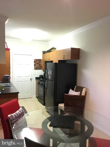 a kitchen with a table chairs refrigerator and microwave
