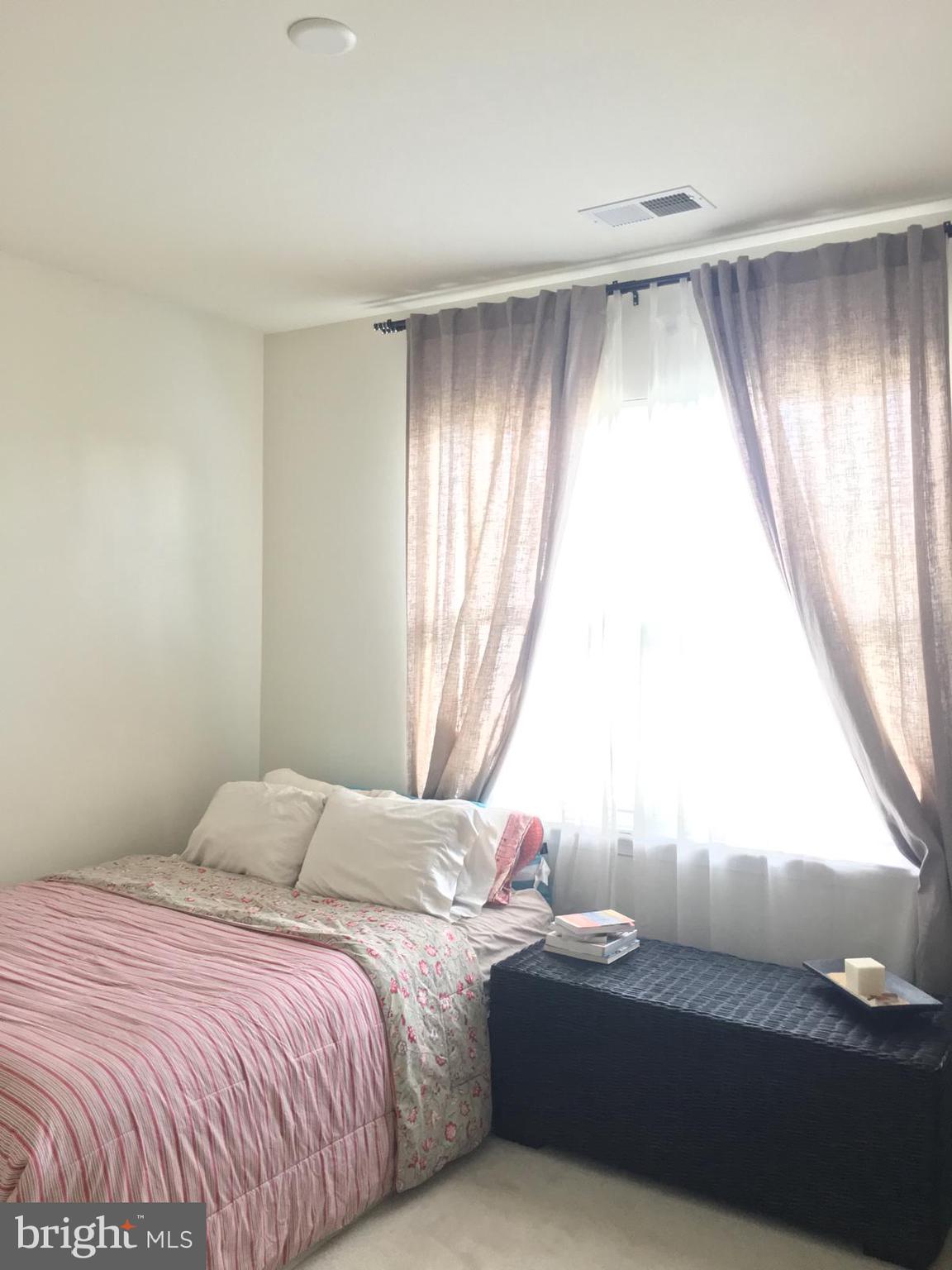 19609 Galway Bay Circle, Unit 303 Germantown, MD 20874 - Photo 10 of 22 a bedroom with a bed and a large window