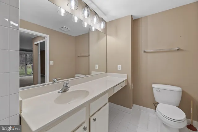 a bathroom with a sink toilet vanity and shower