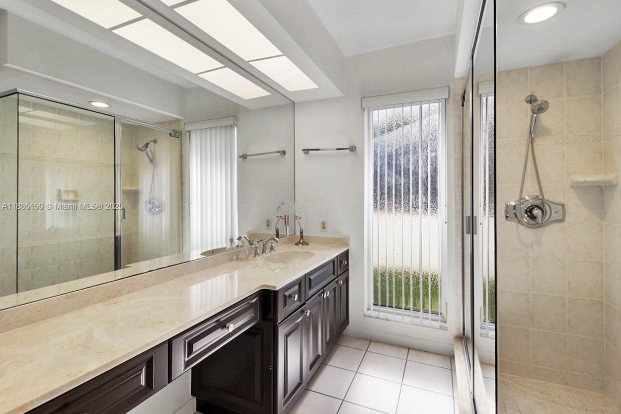 19125 Waterway Road Jupiter, FL 33469 - Photo 17 of 33 a bathroom with a granite countertop sink a shower and a mirror