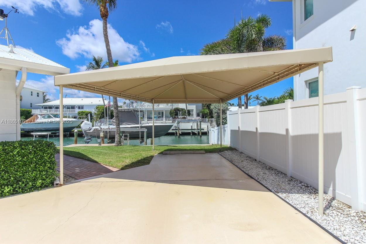 19125 Waterway Road Jupiter, FL 33469 - Photo 19 of 33 a view of a backyard with table and chairs under an umbrella