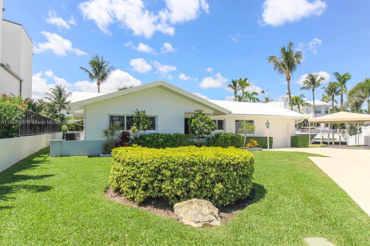 19125 Waterway Road Jupiter, FL 33469 - Photo 2 of 33 a front view of a house with garden