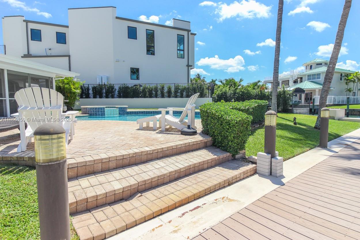 19125 Waterway Road Jupiter, FL 33469 - Photo 32 of 33 a view of a patio with couches table and chairs with wooden floor and fence