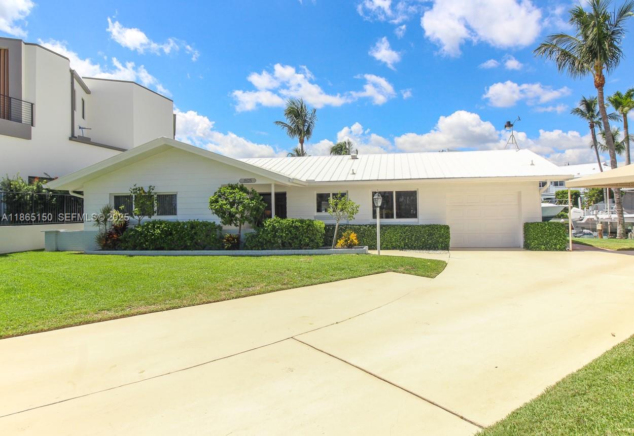 19125 Waterway Road Jupiter, FL 33469 - Photo 33 of 33 a view of a white house with a big yard and potted plants