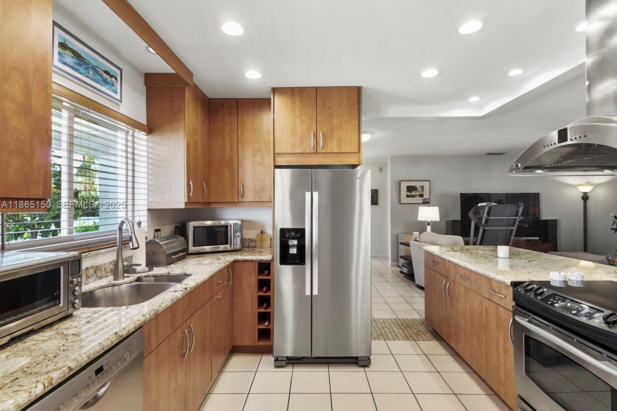 19125 Waterway Road Jupiter, FL 33469 - Photo 5 of 33 a large kitchen with stainless steel appliances granite countertop a stove top oven a refrigerator a sink and dishwasher