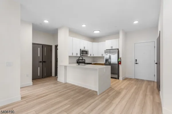 a kitchen with white cabinets and stainless steel appliances