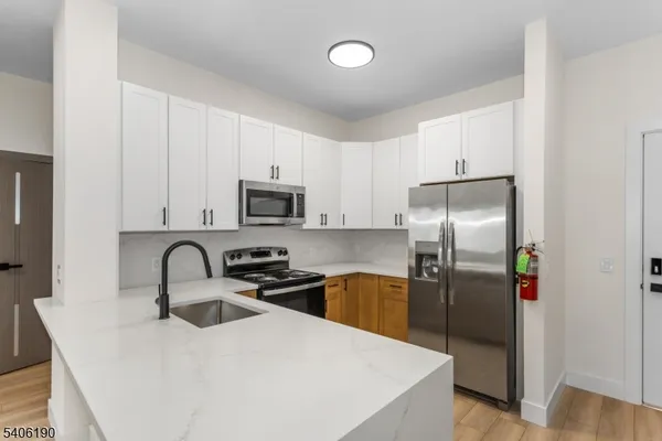 a kitchen with stainless steel appliances a refrigerator a sink a stove and cabinets