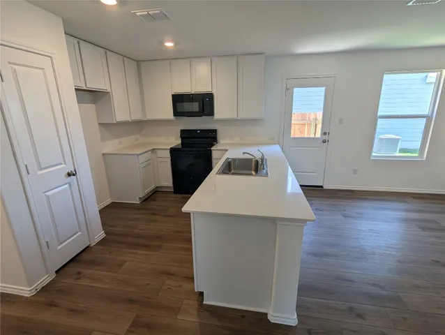 a view of kitchen with wooden floor and electronic appliances