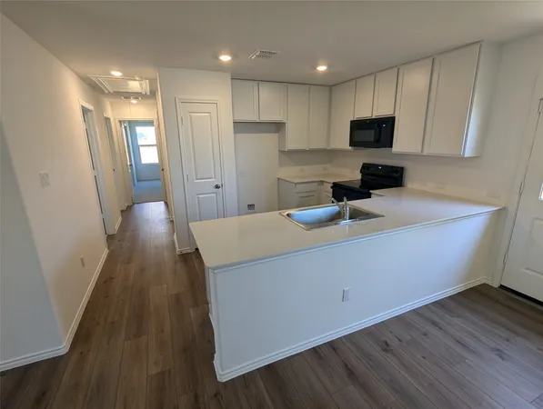 a kitchen with a sink stove and microwave