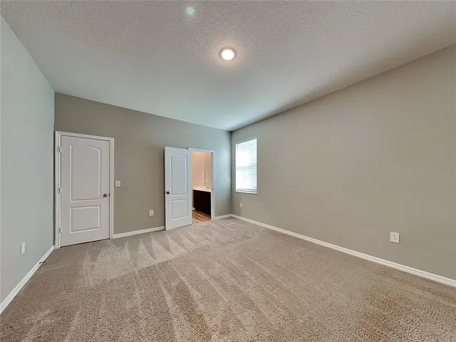 an empty room with windows and fireplace